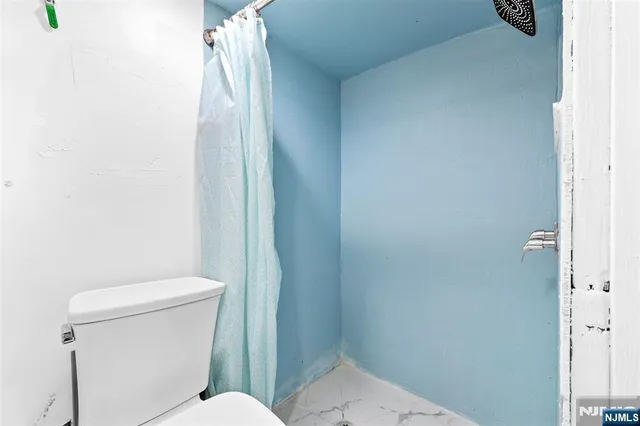 a white toilet sitting next to a shower
