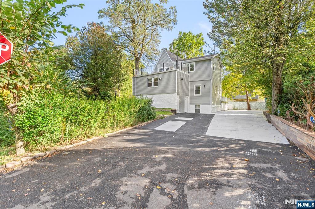 234 Liberty Road Teaneck, NJ 07666 - Photo 33 of 42 a front view of a house with a yard and a tree