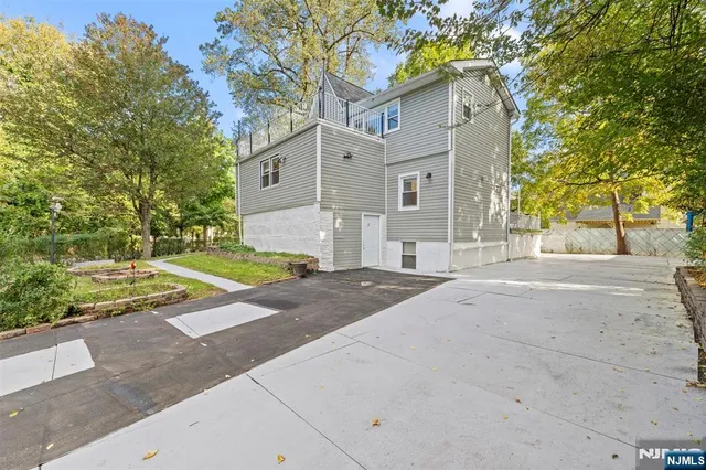 a view of a white house with a yard and plants