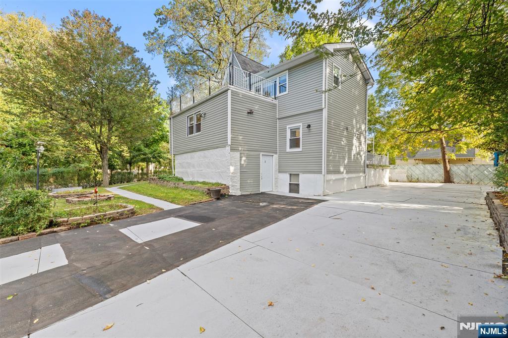 234 Liberty Road Teaneck, NJ 07666 - Photo 35 of 42 a view of a white house with a small yard and large tree