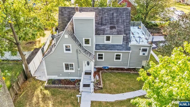 a view of a house with a yard and large tree