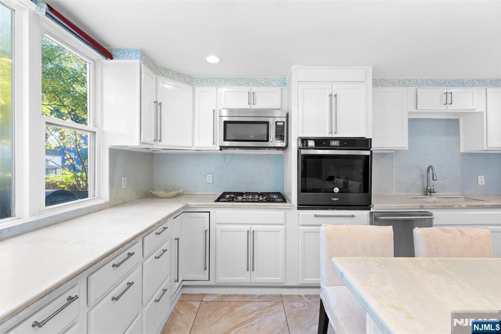 234 Liberty Road Teaneck, NJ 07666 - Photo 7 of 42 a kitchen with stainless steel appliances granite countertop a stove a sink and a microwave