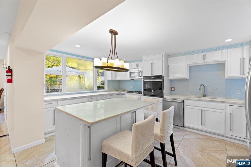 234 Liberty Road Teaneck, NJ 07666 - Photo 8 of 42 a kitchen with a stove a table and chairs in it