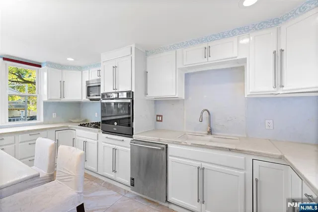 a kitchen with granite countertop white cabinets white appliances and sink