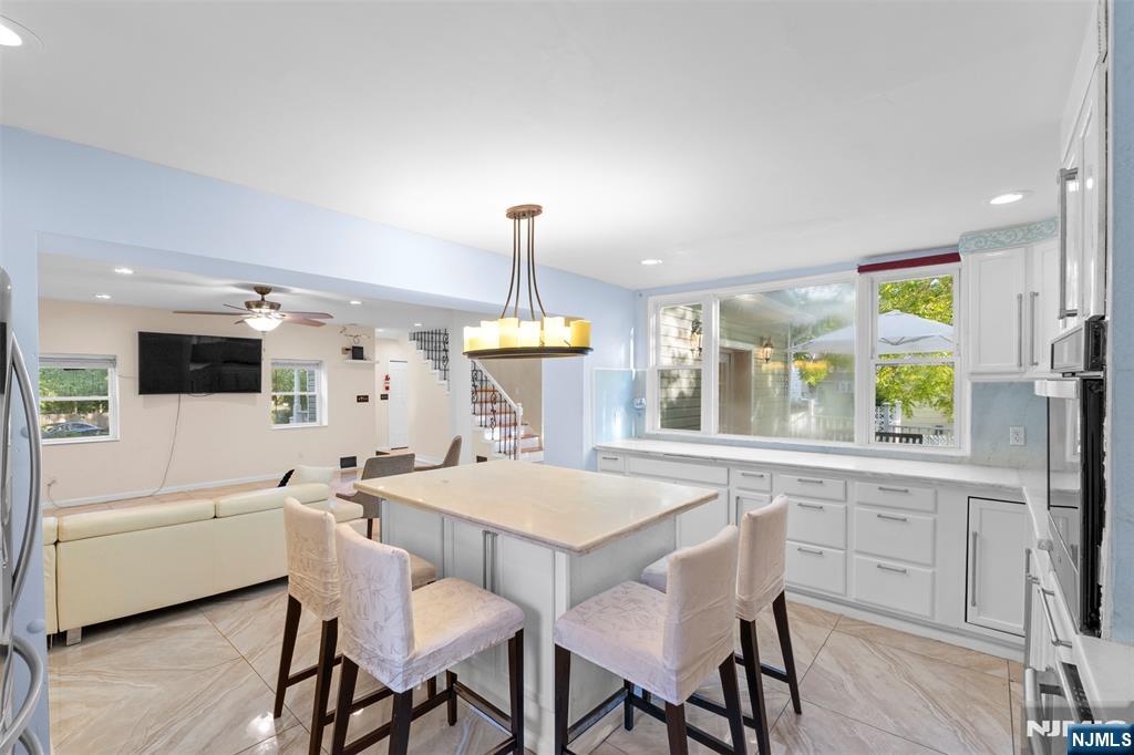 234 Liberty Road Teaneck, NJ 07666 - Photo 10 of 42 a kitchen with a dining table chairs and white cabinets