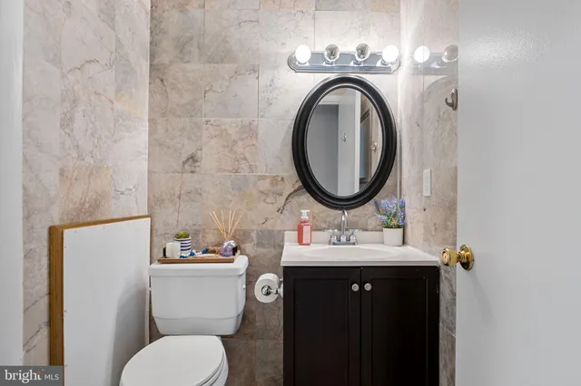 a bathroom with a granite countertop toilet sink and a mirror
