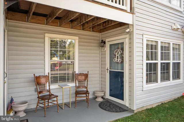 a view of a chair and table in the back yard of the house