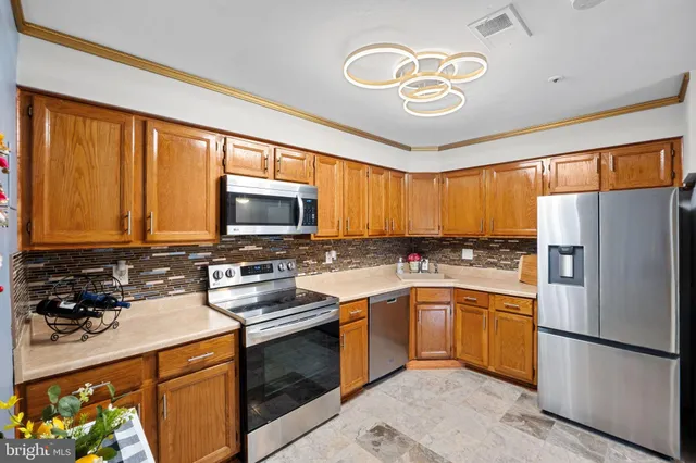 a kitchen with stainless steel appliances a stove refrigerator sink and microwave
