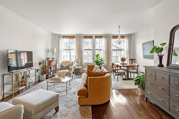 a living room with furniture a flat screen tv and a large window