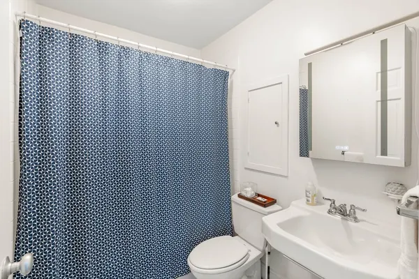 a bathroom with a sink a toilet and mirror