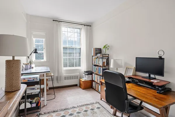 a view of a workspace with furniture and a window