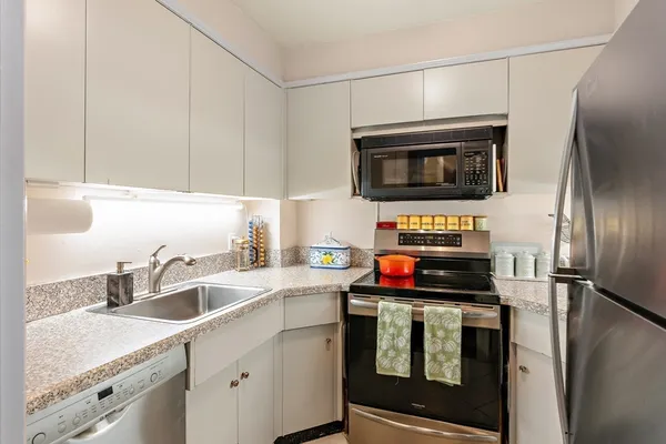 a kitchen with stainless steel appliances a stove a microwave and a sink