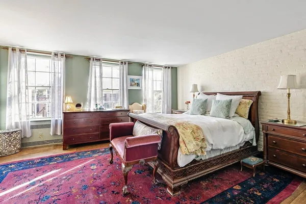 a bedroom with a bed chair and a window