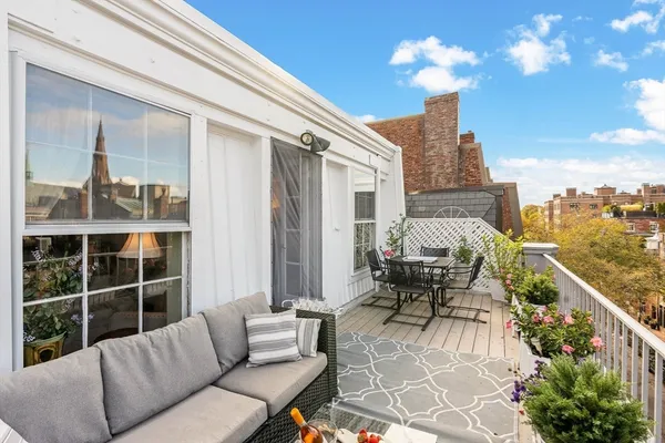 a balcony with furniture and a potted plant