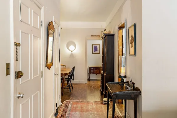 a view of a hallway with chairs and furniture