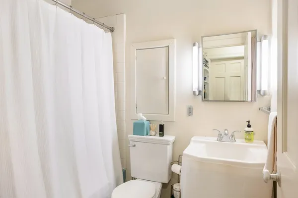 a bathroom with a sink a toilet and a mirror