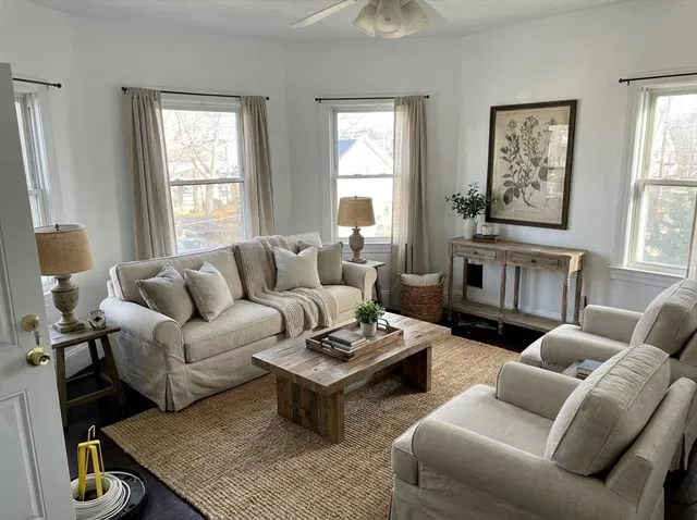 a living room with furniture a rug and windows