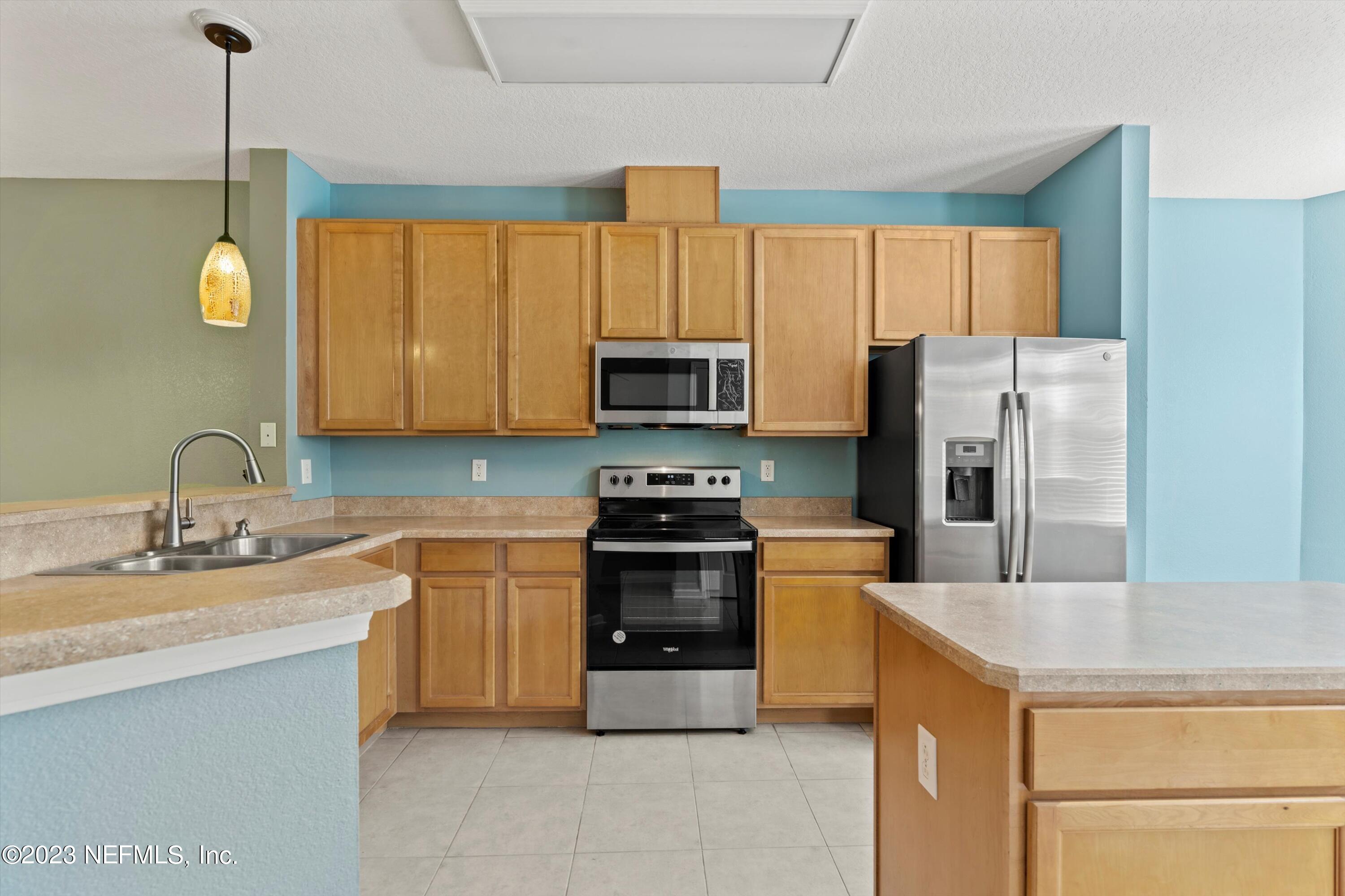 5663 Greenland Road, Unit 1005 Jacksonville, FL 32258 - Photo 13 of 30 a kitchen with a sink a stove and refrigerator