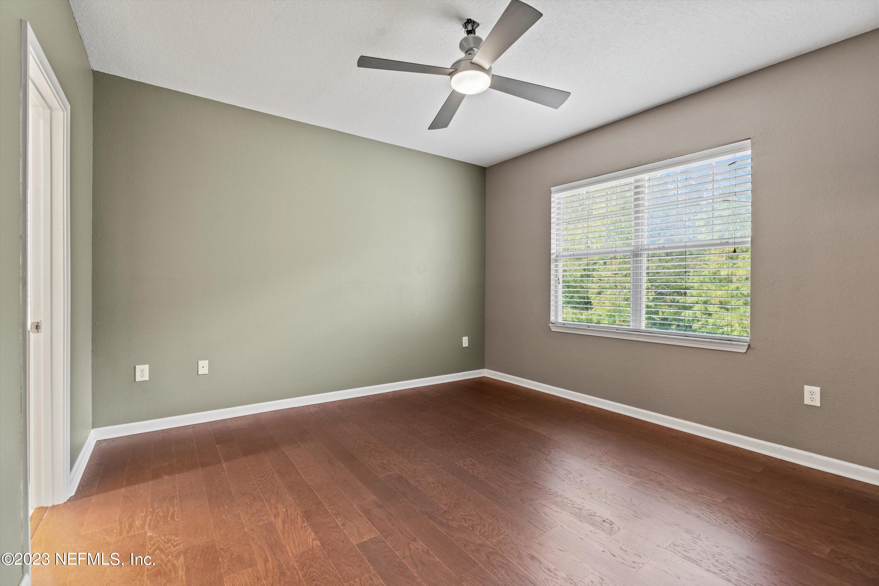 5663 Greenland Road, Unit 1005 Jacksonville, FL 32258 - Photo 19 of 30 an empty room with wooden floor and windows