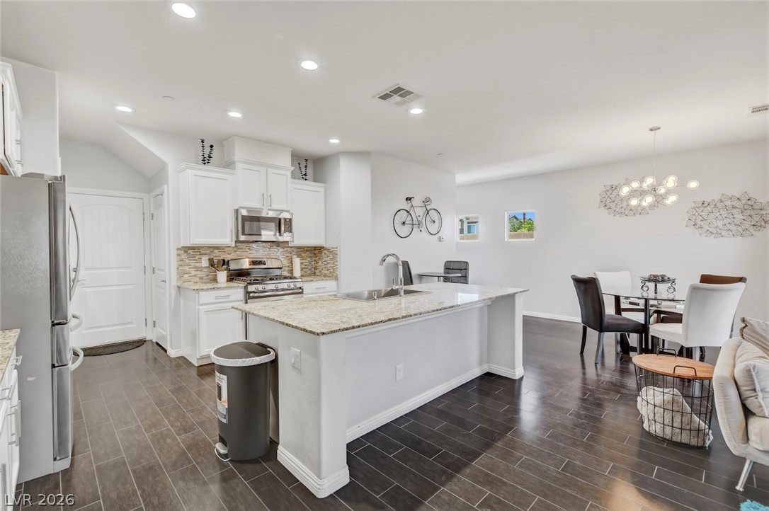 48 Jasmine Point Street Henderson, NV 89074 - Photo 21 of 62 A well-appointed kitchen and dining area features sleek countertops and abundant natural light.