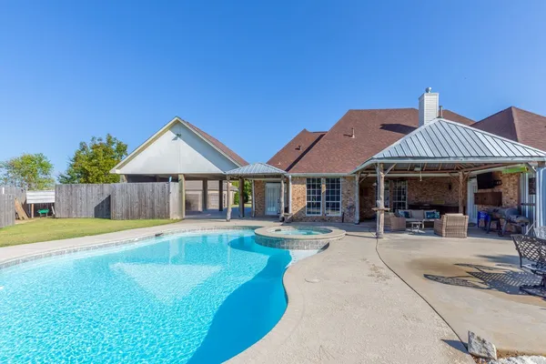 a view of a house with swimming pool and sitting area