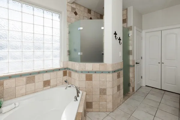 a bathroom with a bathtub and next to a window
