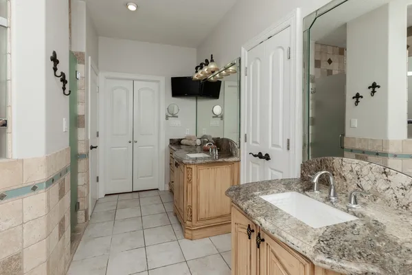 a bathroom with a granite countertop sink a toilet and a mirror
