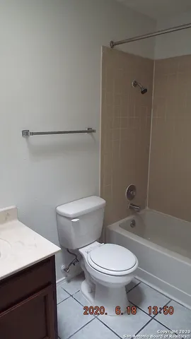 a white toilet sitting next to a bath tub