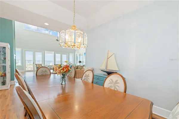 a view of a dining room with furniture a chandelier and wooden floor