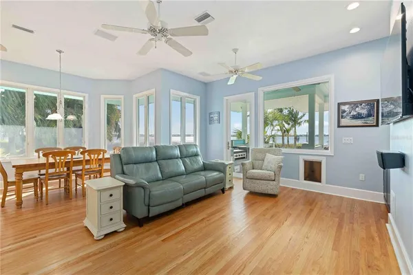a hall with kitchen island a sink dishwasher a stove a refrigerator and a dining table with wooden floor