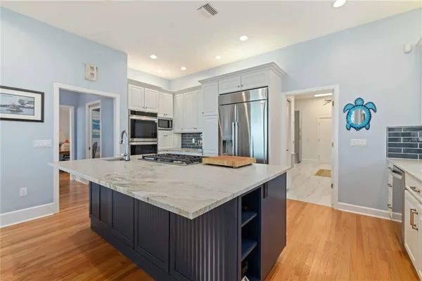 a kitchen with kitchen island granite countertop a sink and refrigerator