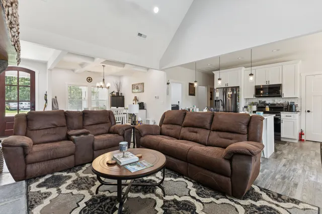 a living room with furniture a rug and a kitchen view