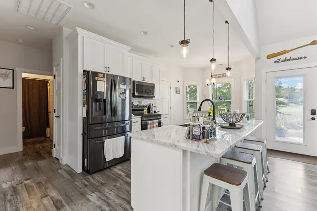 a kitchen with stainless steel appliances granite countertop a refrigerator and a stove top oven