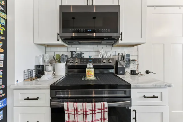 a kitchen with stainless steel appliances granite countertop a stove and a microwave
