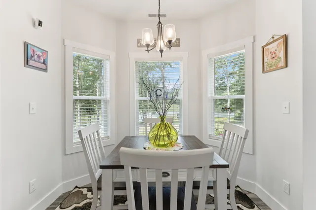 a dining room with furniture a chandelier and wooden floor