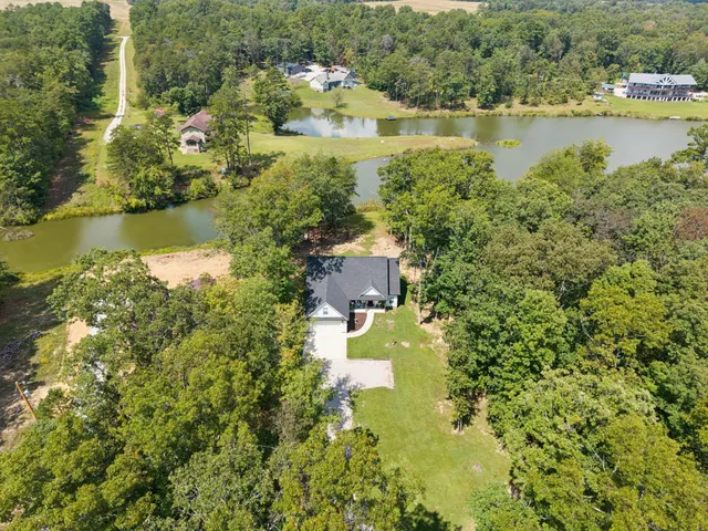 a view of a house with a yard and large trees