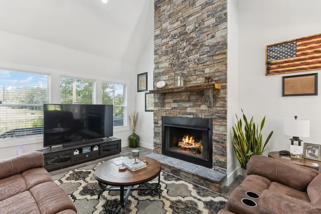 a living room with furniture a flat screen tv and a fireplace