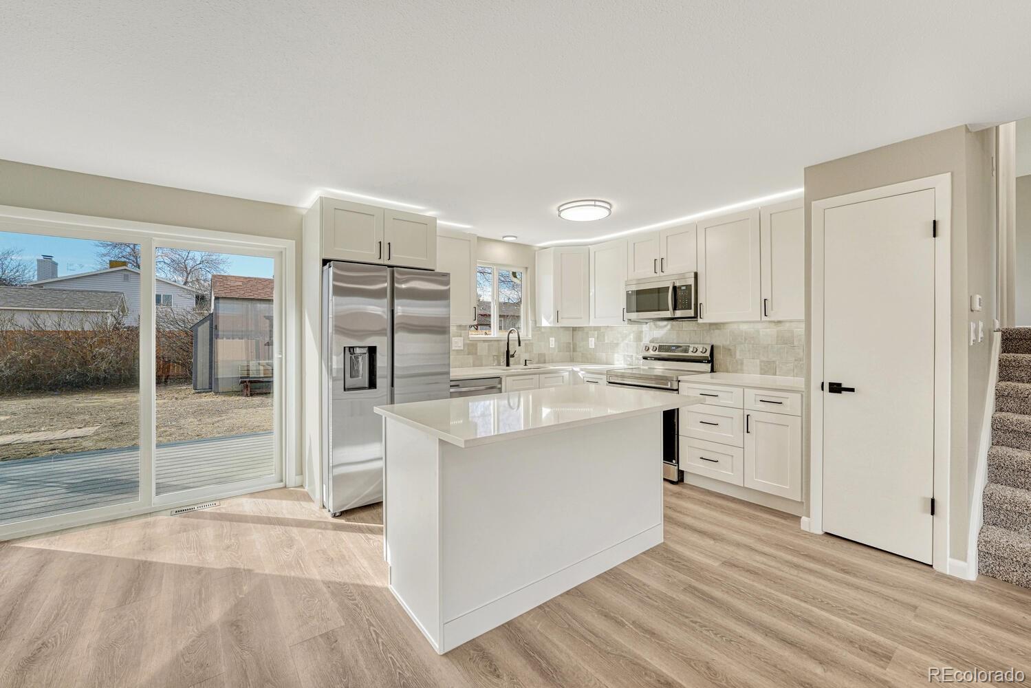 7121 Xavier Street Westminster, CO 80030 - Photo 4 of 23 a kitchen with stainless steel appliances a refrigerator sink and cabinets