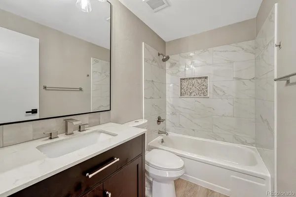 a bathroom with a tub sink toilet and a mirror
