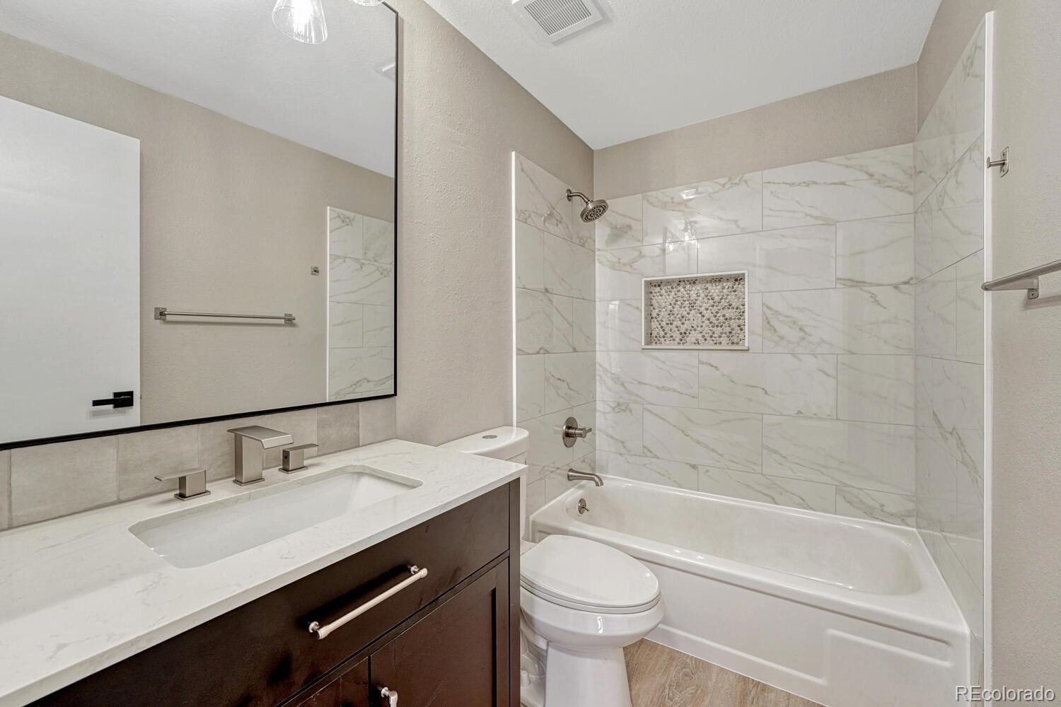 7121 Xavier Street Westminster, CO 80030 - Photo 9 of 23 a bathroom with a tub sink toilet and a mirror