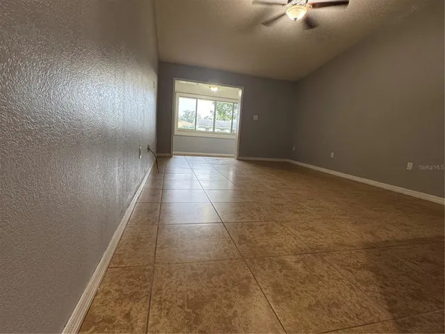 a view of a livingroom with wooden floor and a ceiling fan