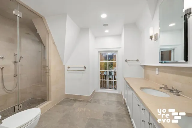 a bathroom with a granite countertop sink a toilet and shower