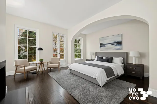 a spacious bedroom with a bed a couch and a fireplace