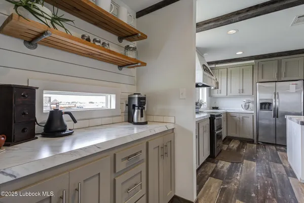 a kitchen with stainless steel appliances granite countertop a stove refrigerator and cabinets