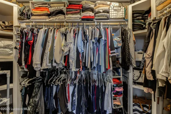 a view of a backyard with wooden fence and a large tree
