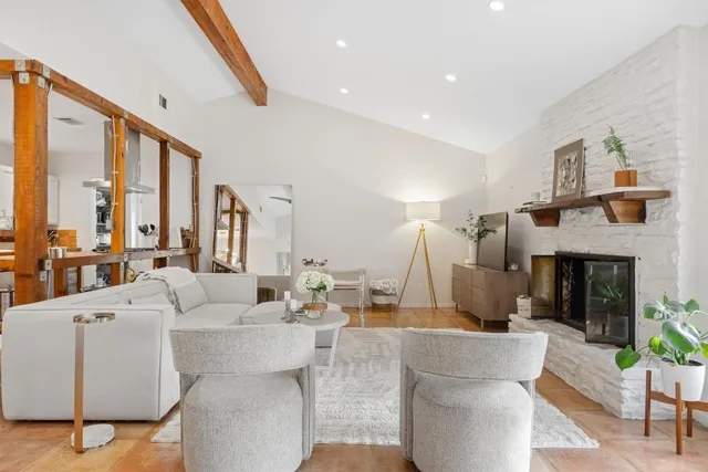 a living room with fireplace furniture and a large window