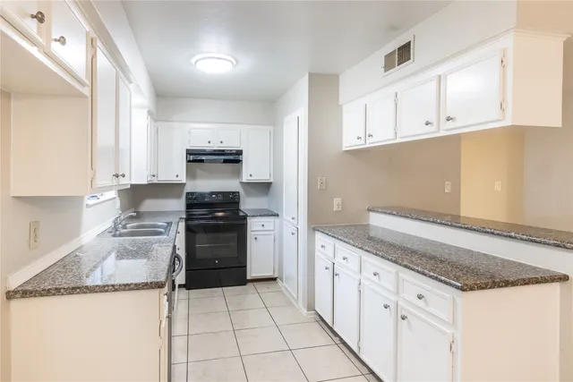 a view of a kitchen with white cabinets