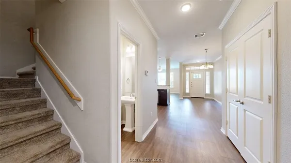 a view of a hallway with wooden floor and staircase