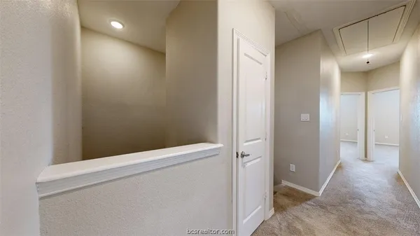 a view of hallway with bathroom