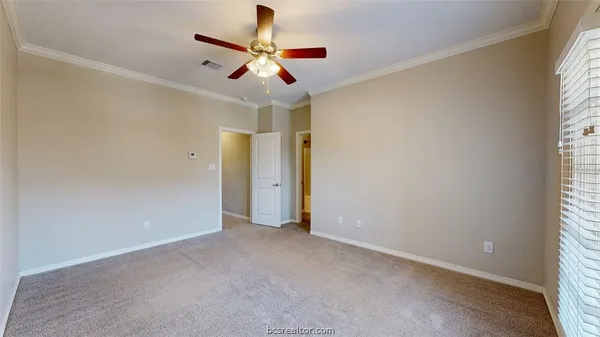 an empty room with a window and a fan